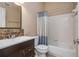 Traditional bathroom showcasing dark wood vanity, a white tub and toilet, and beige walls at 5022 Anclote Dr, Alpharetta, GA 30022