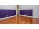 Bedroom showcasing hardwood floors, a purple accent wall, white trim, and white doors at 5022 Anclote Dr, Alpharetta, GA 30022