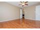 Neutral bedroom featuring hardwood floors, a ceiling fan, white trim, and two white doors at 5022 Anclote Dr, Alpharetta, GA 30022