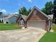 Charming brick home featuring an attached two-car garage and well-maintained front yard with bay window at 5022 Anclote Dr, Alpharetta, GA 30022