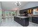 Modern kitchen features an island, tile floors, gray cabinets, stainless steel appliances, and access to the deck at 5022 Anclote Dr, Alpharetta, GA 30022