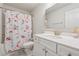 Well-lit bathroom featuring a shower, toilet, sink, white cabinets, and a gold-framed mirror at 5545 Adirondack Dr, Cumming, GA 30040