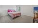Bright bedroom featuring carpeted floors, a window, and a comfortable pink bed with soft pillows at 5545 Adirondack Dr, Cumming, GA 30040