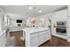 Open concept kitchen with white cabinets, an island, and views of the living room with a fireplace at 5545 Adirondack Dr, Cumming, GA 30040