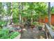 Back deck with dining set, potted plants, and lush green view, perfect for outdoor dining and relaxation at 686 Hillwood Ct, Dacula, GA 30019