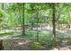Scenic backyard featuring mature trees with partially fenced border at 686 Hillwood Ct, Dacula, GA 30019