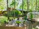 Secluded backyard with lush greenery, patio set, and a charming greenhouse, perfect for outdoor relaxation at 686 Hillwood Ct, Dacula, GA 30019