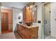 Bathroom featuring wooden cabinetry, granite countertop, and a glass shower at 686 Hillwood Ct, Dacula, GA 30019