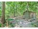 View of a fenced in chicken coop with ramp and seating outside in a lush wooded area at 686 Hillwood Ct, Dacula, GA 30019