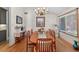 Elegant dining room featuring a large table, chandelier, hardwood floors, and bright natural light at 686 Hillwood Ct, Dacula, GA 30019