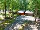 Unique exterior featuring two-car garage and a driveway, surrounded by mature trees and lush greenery at 686 Hillwood Ct, Dacula, GA 30019