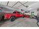 Spacious garage featuring a red truck, ceiling fan, and ample storage, offering functionality and convenience at 686 Hillwood Ct, Dacula, GA 30019