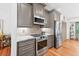 Well-equipped kitchen with stainless steel appliances, granite countertops, and wooden flooring at 686 Hillwood Ct, Dacula, GA 30019
