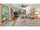 Comfortable living room featuring hardwood floors, a ceiling fan, and large window views of the lush outdoors at 686 Hillwood Ct, Dacula, GA 30019