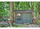 Charming outdoor storage shed with a window and flower boxes for added curb appeal and functionality at 686 Hillwood Ct, Dacula, GA 30019