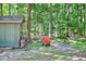 Side view of outdoor storage shed with lush greenery, tools and equipment storage space at 686 Hillwood Ct, Dacula, GA 30019