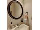 Powder room with round mirror, sink and bronze fixtures at 1668 Legrand Cir, Lawrenceville, GA 30043