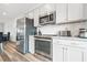 Close-up of a kitchen featuring stainless steel appliances and white subway tile backsplash at 3641 Princeton Ave, Atlanta, GA 30337