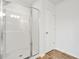 Modern bathroom shower with glass door and tile surround, plus wood-look flooring at 3641 Princeton Ave, Atlanta, GA 30337