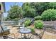 Relax on the stone patio in a lush backyard, complemented by verdant landscaping and a classic white picket fence at 510 Elgaen Ct, Roswell, GA 30075