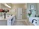 Bright bathroom with dual sinks, white cabinets, and a separate tub and shower at 510 Elgaen Ct, Roswell, GA 30075
