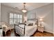 Neutral bedroom featuring hardwood floors, black metal bed frame, and a wicker chair at 510 Elgaen Ct, Roswell, GA 30075