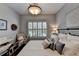 Comfortable bedroom featuring a decorative light fixture, white and gray decor, and a window with plantation shutters at 510 Elgaen Ct, Roswell, GA 30075