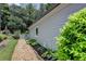 Exterior of home with gravel walkway, window, gray siding, and landscaped greenery at 510 Elgaen Ct, Roswell, GA 30075