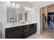 Bright bathroom featuring double vanity, black cabinetry, and convenient access to a walk-in closet at 5504 Cameron Parc Dr, Alpharetta, GA 30022