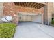 Exterior view of a two-car garage with a white door, gas meter, and a satellite dish at 5504 Cameron Parc Dr, Alpharetta, GA 30022