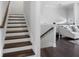 A modern staircase with wood treads, white risers, and a view into a bright living space at 5504 Cameron Parc Dr, Alpharetta, GA 30022