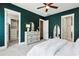 This main bedroom has dark teal walls, a ceiling fan, and doorways to a walk-in closet and bathroom at 704 Banton Nw Dr, Atlanta, GA 30318