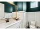 Stylish powder room with white wainscoting and a framed mirror at 704 Banton Nw Dr, Atlanta, GA 30318