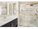 Elegant bathroom with double vanity, stylish mirror, and glass enclosed shower at 9025 Huntcliff Trce, Atlanta, GA 30350