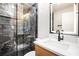 Modern bathroom featuring marble shower with glass enclosure and backlit mirror with vanity at 9025 Huntcliff Trce, Atlanta, GA 30350