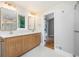 Bathroom with double vanity, wood cabinets, and a glass-enclosed shower with gold fixtures at 9025 Huntcliff Trce, Atlanta, GA 30350