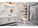 Modern bathroom featuring marble shower with glass enclosure, vanity, and backlit mirror at 9025 Huntcliff Trce, Atlanta, GA 30350