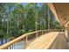 Large wooden deck with view of inground pool and lush greenery provides outdoor living space at 9025 Huntcliff Trce, Atlanta, GA 30350