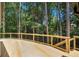 Expansive wooden deck surrounded by lush greenery offers serene outdoor living at 9025 Huntcliff Trce, Atlanta, GA 30350