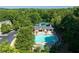 An aerial view of a community pool area with a pool, clubhouse, tennis court, parking, and landscaping at 998 Poplar Mill Ct, Buford, GA 30518