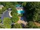 An aerial view of a pool, playground, tennis court, and parking area surrounded by many trees at 998 Poplar Mill Ct, Buford, GA 30518