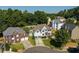 An aerial view of a neighborhood highlighting several homes, landscaping, and a tree line at 998 Poplar Mill Ct, Buford, GA 30518