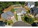 An aerial view of a neighborhood showcasing landscaping, a pool, and backyard patio at 998 Poplar Mill Ct, Buford, GA 30518
