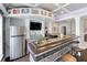 Basement wet bar featuring black and white tiled bar, stainless fridge, and sports decor at 998 Poplar Mill Ct, Buford, GA 30518
