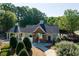 An exterior view of a clubhouse with brick accents, a gated entrance, and landscaping at 998 Poplar Mill Ct, Buford, GA 30518