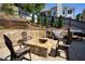 Backyard stone fire pit area with chairs and a manicured lawn, perfect for outdoor gatherings at 998 Poplar Mill Ct, Buford, GA 30518