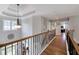 Hallway featuring hardwood floors and staircase with decorative chandelier and windows at 998 Poplar Mill Ct, Buford, GA 30518