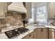 Kitchen area with a stainless steel range, undermount sink, and views of the outside greenery at 998 Poplar Mill Ct, Buford, GA 30518