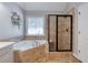 Main bathroom featuring a soaking tub, separate glass shower and decorative stained glass window at 998 Poplar Mill Ct, Buford, GA 30518