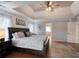 Main bedroom with tray ceilings, hardwood floors, and a decorative ceiling fan at 998 Poplar Mill Ct, Buford, GA 30518